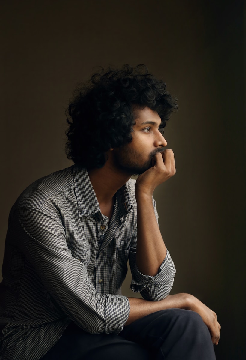 man in gray and white checkered dress shirt thinking about life insurance